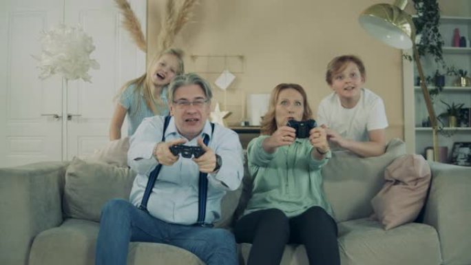 奶奶和爷爷在玩游戏机，孙子孙女在为他们加油