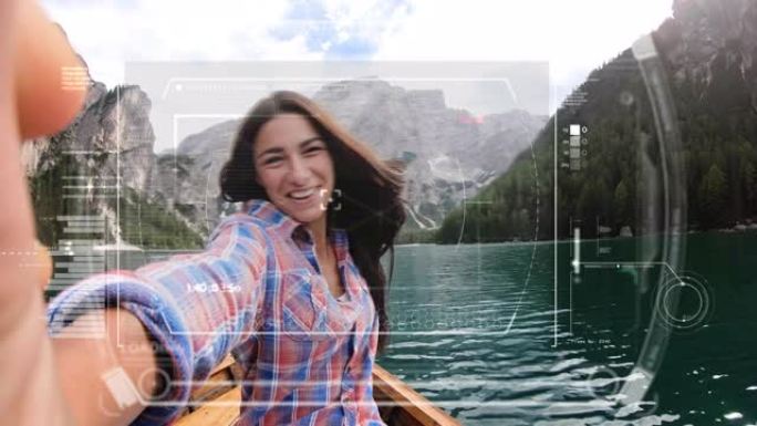 一名年轻女子正在使用带有增强现实全息图的未来派智能手机，在湖中央的一艘船上与朋友和家人进行视频通话