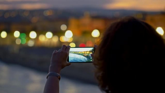 女人用智能手机拍摄夜城。不错，法国。4K, UHD