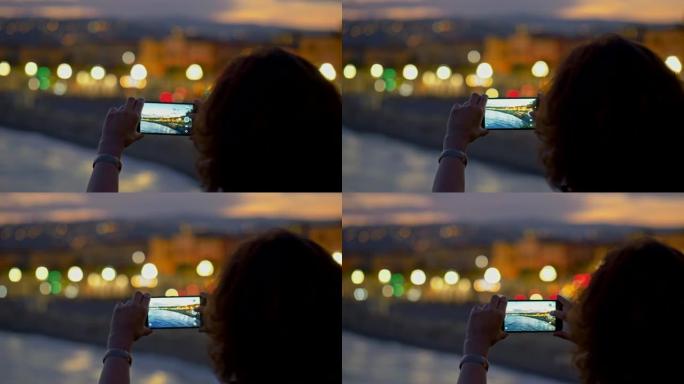 女人用智能手机拍摄夜城。不错，法国。4K, UHD