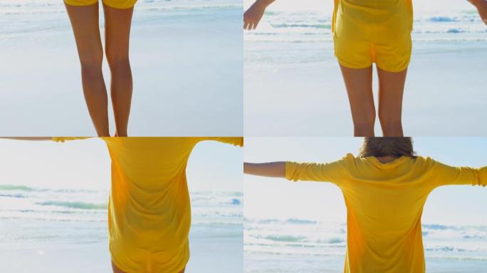 年轻的白人妇女站在海滩上的后视图，双臂伸出4k