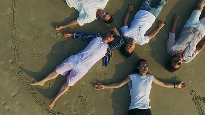 年轻的亚洲成年人躺在沙滩上闭着眼睛