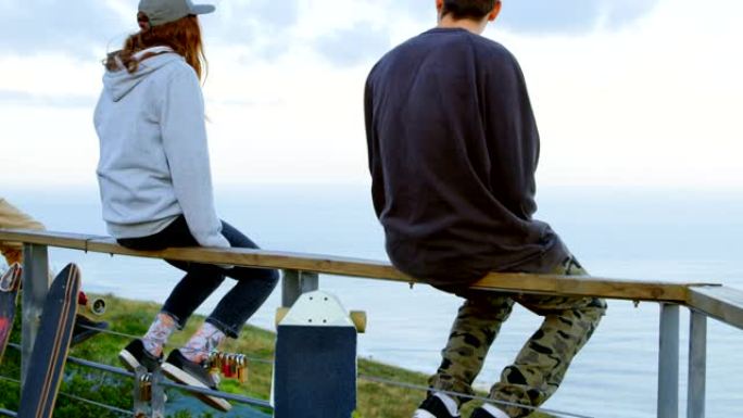 年轻的高加索滑板手的后视图，滑板坐在4k观察点的栏杆上