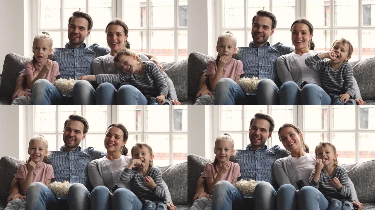 快乐的父母和可爱的小孩在家里看电视