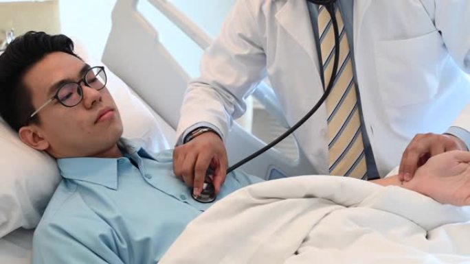 一名亚洲男医生在医院用听诊器对患者进行医疗检查