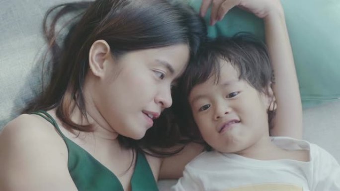 年轻的亚洲母亲和男婴在床上拥抱