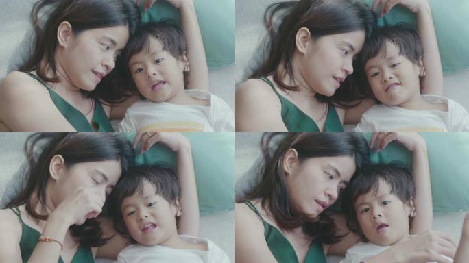 年轻的亚洲母亲和男婴在床上拥抱