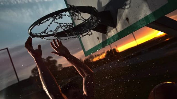 CU超级SLO MO TIMEWARP EFFECT男子在黄昏时在篮筐中灌篮湿篮球