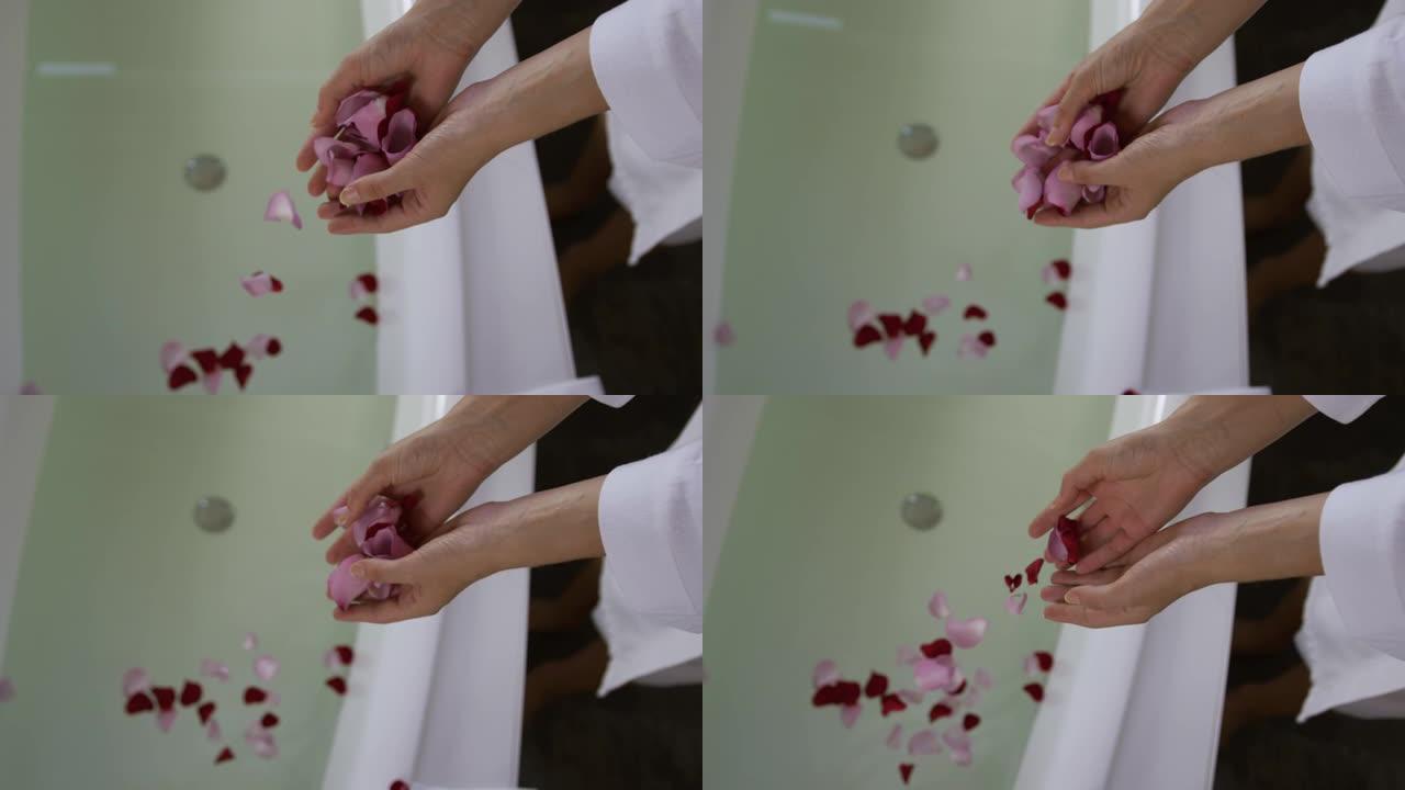 白人妇女在酒店的浴缸里放玫瑰花瓣