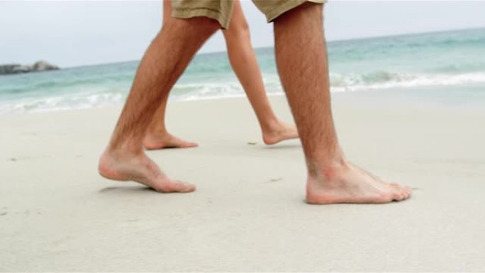 低矮的情侣赤脚走在海滩4k