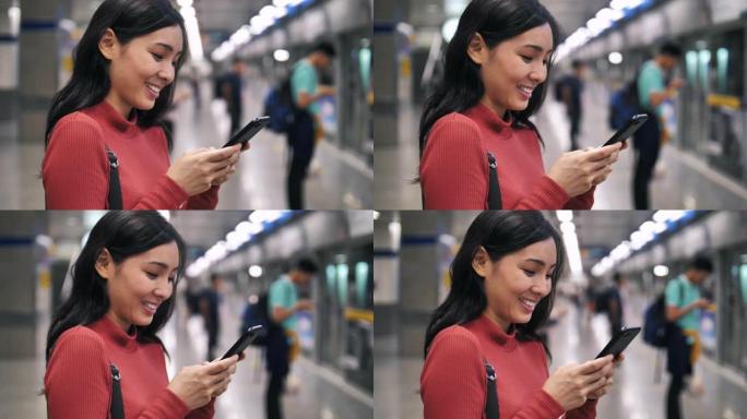使用智能手机地铁站的亚洲女性