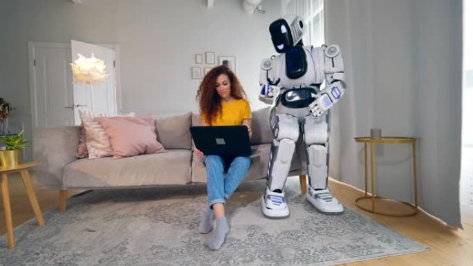 类似人类的半机械人正在看着一位女士在笔记本电脑上工作