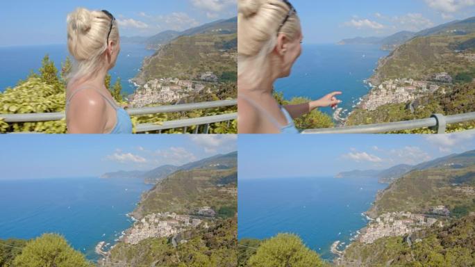 WS年轻女子沿着栏杆行走，俯瞰风景秀丽的海景，五渔村，意大利