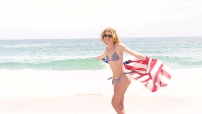 在海滩上挥舞着美国国旗的白人妇女的侧视图4k
