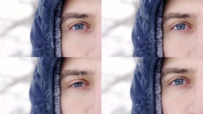一个男人的蓝眼睛在房间里看着，而雪从空中以慢动作落下。