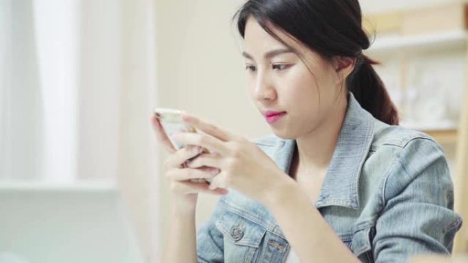 慢动作: 关闭亚洲女性在家中使用智能手机发短信