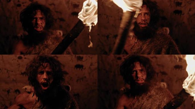 原始穴居人的肖像晚上穿着动物皮站在他的洞穴里，拿着火把攻击。原始尼安德特人猎人/智人尖叫和威胁