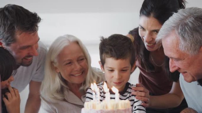 多代家庭在家里与孙子一起庆祝生日，吹灭蜡烛