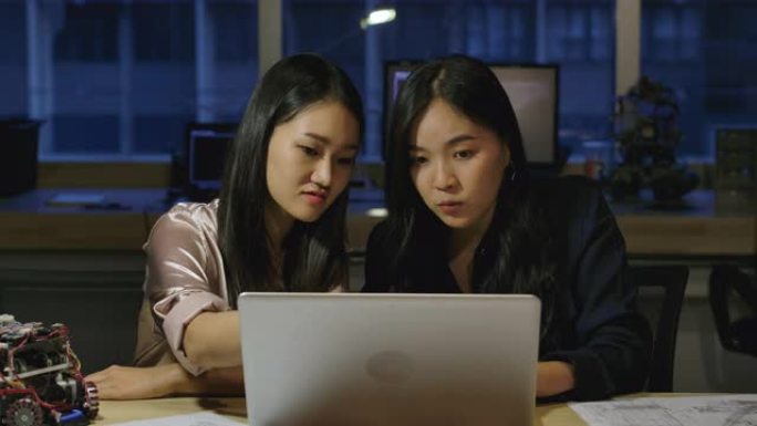 女电子工程师在办公室检查项目。两名亚裔女性在个人电脑上比较数据。有技术或创新概念的人。