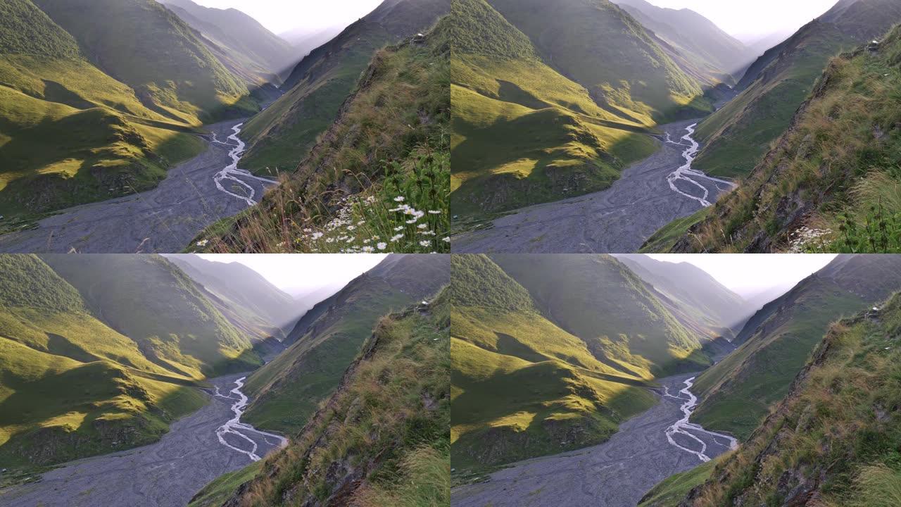 格鲁吉亚图谢蒂高加索山脉的日落。下面是一条狭窄的小溪。在干涸的溪流周围可以看到更大的前河床。起重机射