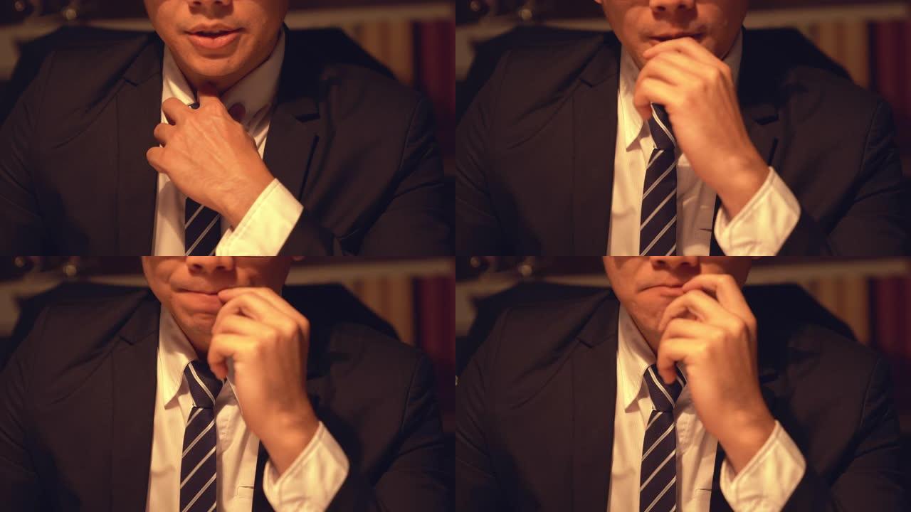 紧张的男人拉直衬衫上的衣领。亚洲年轻商人用严肃体贴的表情调整领带，把目光移开。