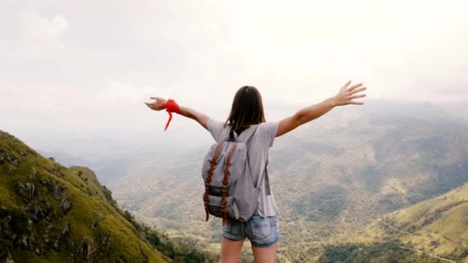 背景图年轻快乐的女性旅行博客作者背着背包站在斯里兰卡史诗山景。