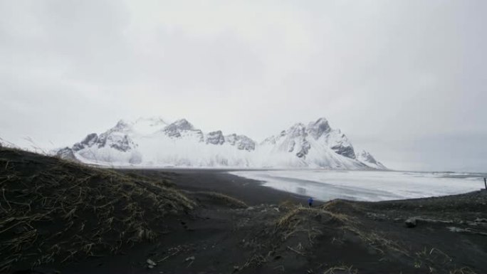 冰岛斯托克尼斯海滩黑沙海滩外的白雪山风景