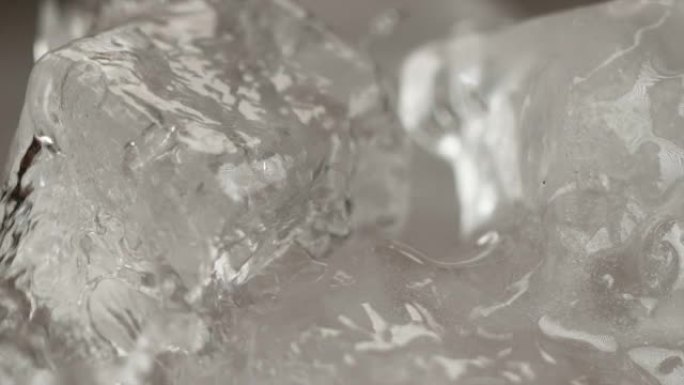 慢动作，微距: 冷水倒在冰块上的详细镜头。