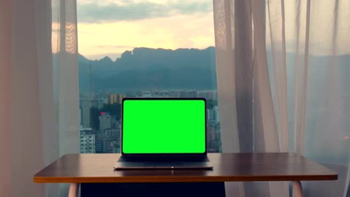 桌子上的笔记本电脑与绿色屏幕