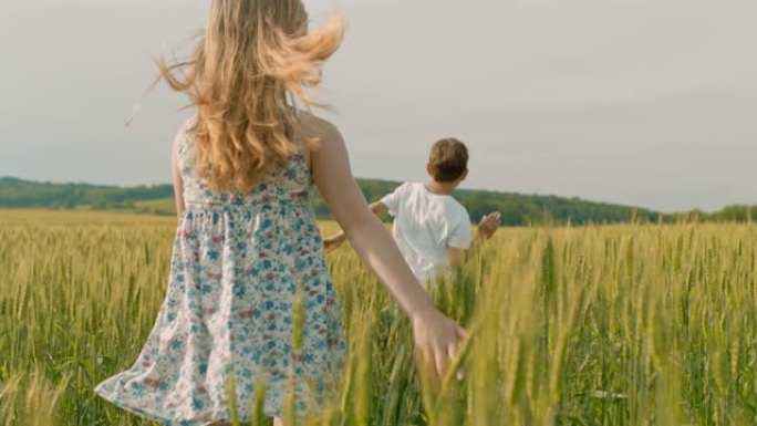 无忧无虑的男孩和女孩在阳光明媚的田园诗般的乡村麦田里奔跑