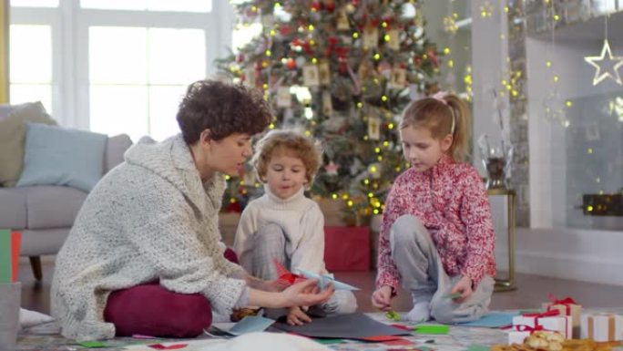 母亲教孩子们如何制作圣诞折纸