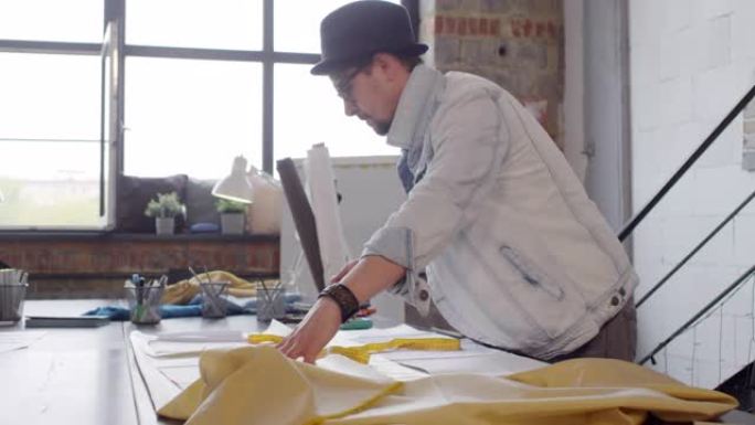 男性裁缝师在缝纫工作室处理图案和织物