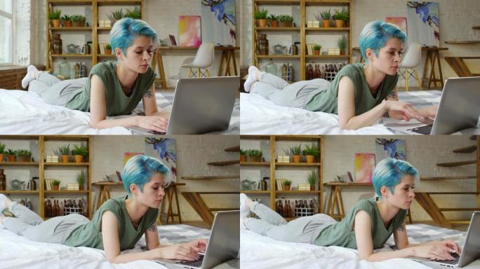 女人躺在床上，在笔记本电脑上打字