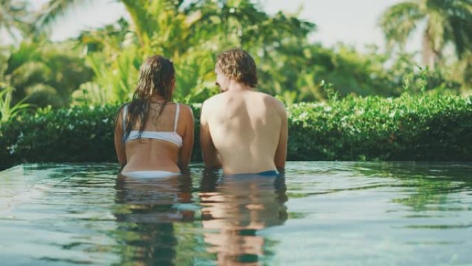 迷人的夫妇享受热带游泳池