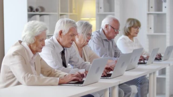 老年人在计算机课上使用笔记本电脑