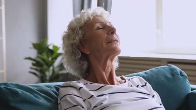 平静成熟的退休妇女呼吸新鲜空气丰满的乳房。