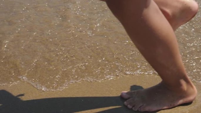 小女孩赤脚在沙滩上奔跑。慢动作。