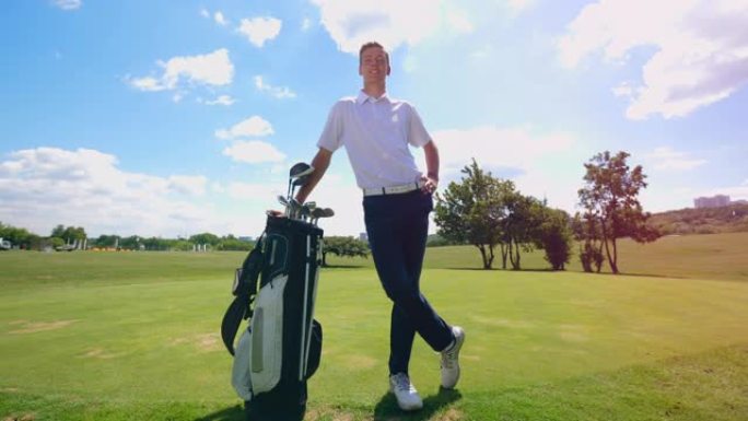 一名高尔夫球手带着他的装备站在球场上。