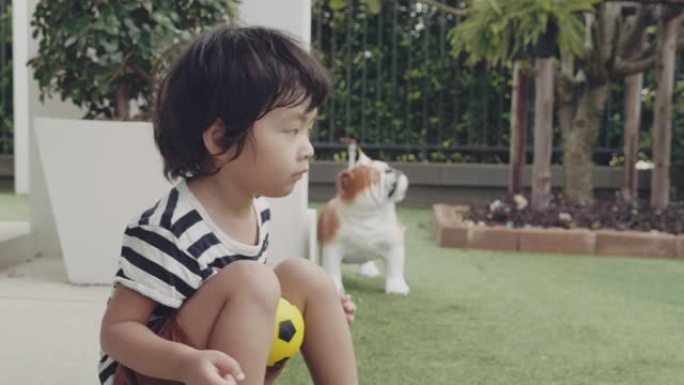 亚洲小男孩踢足球后休息
