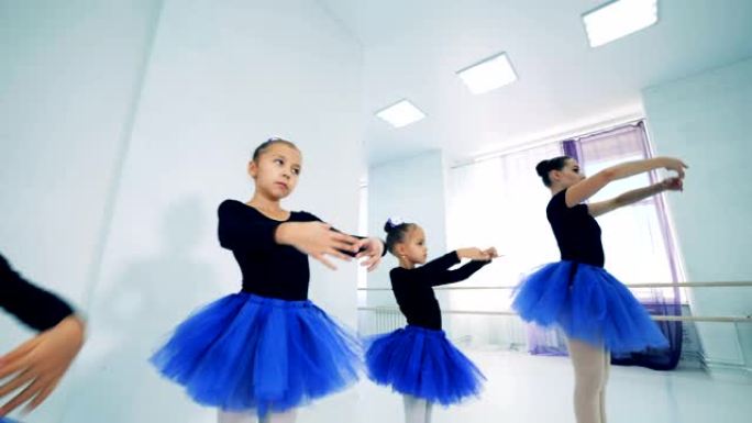 小女孩在芭蕾舞老师之后重复动作