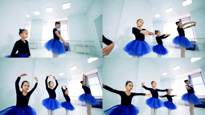 小女孩在芭蕾舞老师之后重复动作