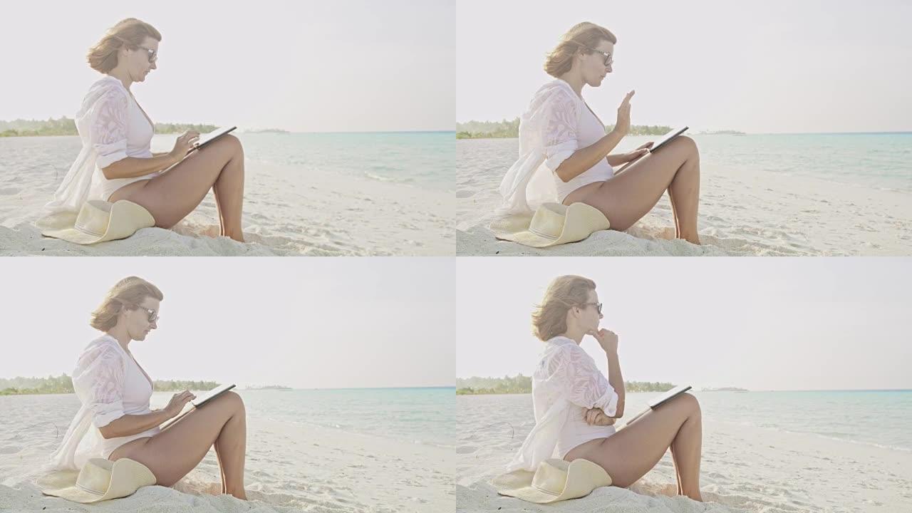 女士在马尔代夫阳光明媚的海洋海滩上与数字平板电脑进行自拍和视频聊天