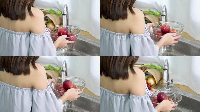 4k; 亚洲女性在厨房房间洗苹果。