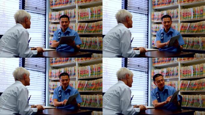 年轻的亚洲男性医生和高级患者在诊所4k讨论数字平板电脑