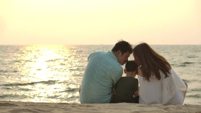剪影快乐的亚洲家庭，一起在日落时在海滩上日落。慢动作。家庭、假期和旅行概念。