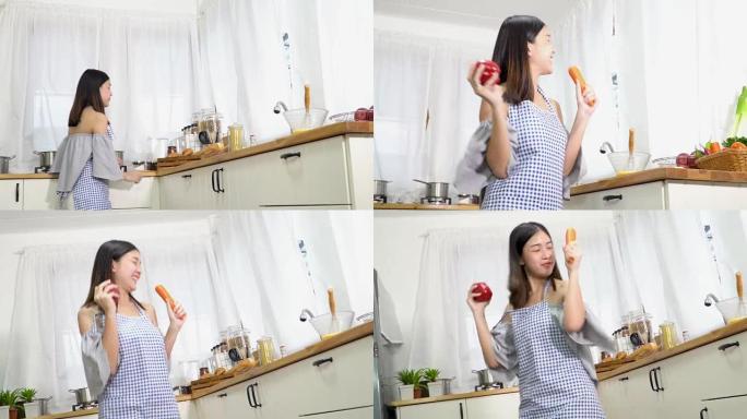 4k; 亚洲女性在厨房里跳舞和拿着蔬菜。