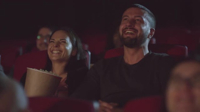 幸福的夫妇在电影院笑
