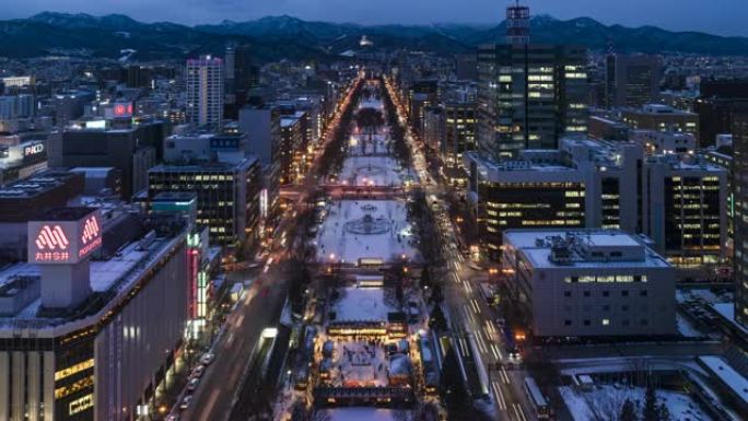 札幌电视塔的大通公园俯视图，黄昏时商业区有红绿灯。