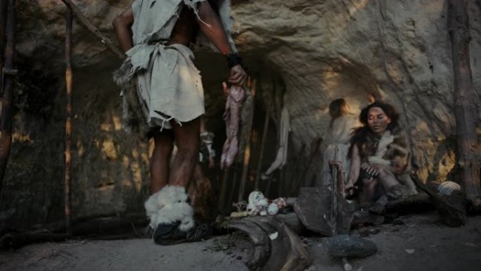 穿着动物皮的狩猎采集者部落生活在一个山洞里。领导者从狩猎中带来动物猎物，女性在篝火上烹饪食物，女孩在