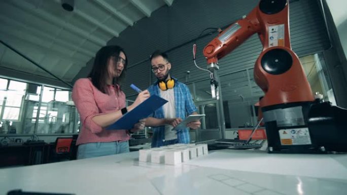 两名工程师正在记录一个机器人的实验